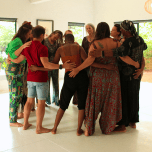 A group of individuals standing in a circle at an in-person facilitated workshop